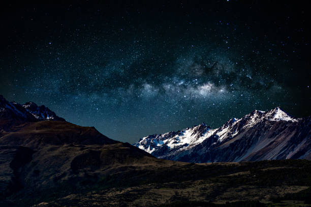 ciel de nuit de fond avec des étoiles et la voie laiteuse au-dessus des montagnes enneigées à l’île du sud nouvelle-zélande - lake night winter sky photos et images de collection