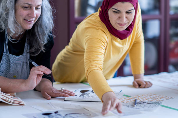 istock Multi-ethnic group of artists reviewing design plans for a textile project 1248049723