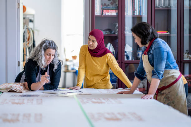 istock Multi-ethnic group of artists reviewing design plans for a textile project 1248049732