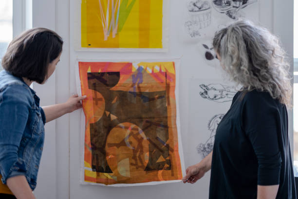 istock Two female artists inspecting textile pieces hanging on studio wall 1248049772