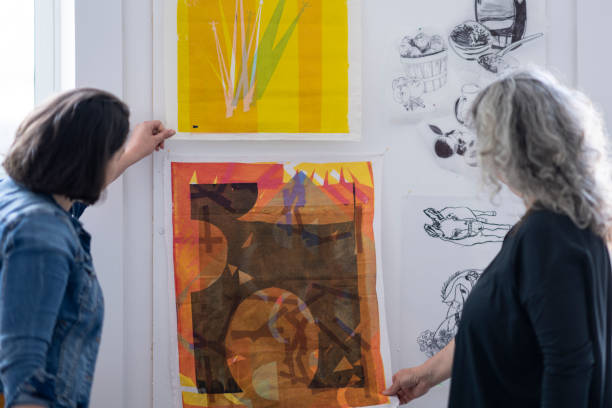 istock Two female artists inspecting textile pieces hanging on studio wall 1248049784