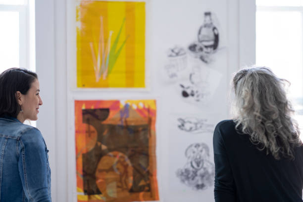 istock Two female artists inspecting textile pieces hanging on studio wall 1248049827