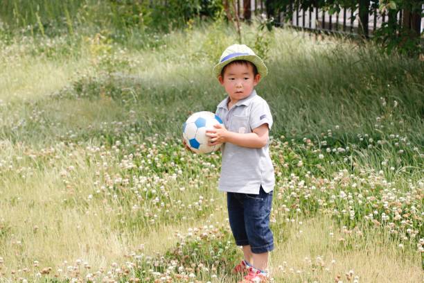 A forgotten orange football on a grass field