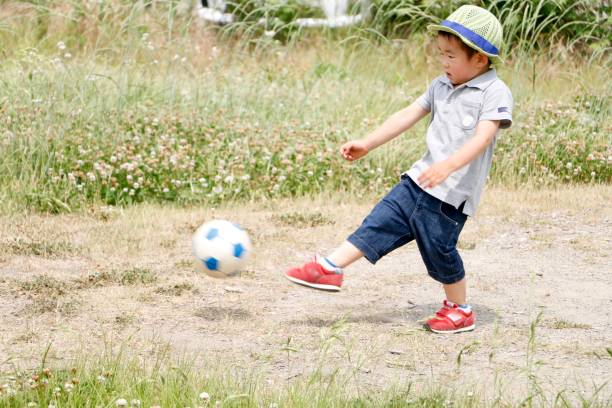 istock Little boy playing soccer ball 1248056882
