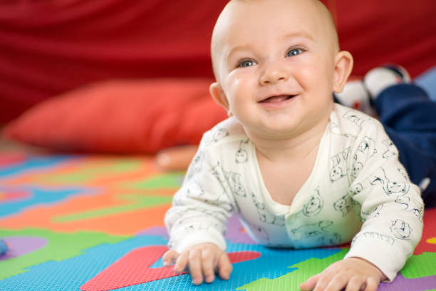 istock Baby crawling on play mat colorful rug smiling 1248061467