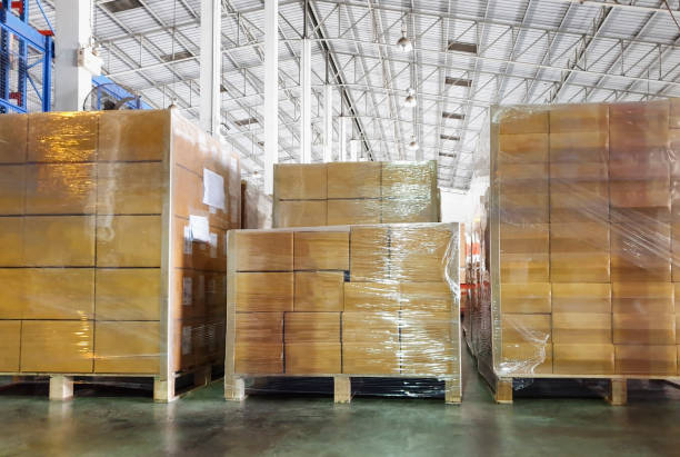 istock Stack of shipments boxes on wooden pallets at interior warehouse storage. 1248064270