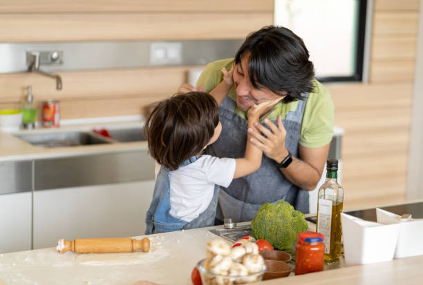 istock Playful father and son having fun while making pizza at home 1248066381