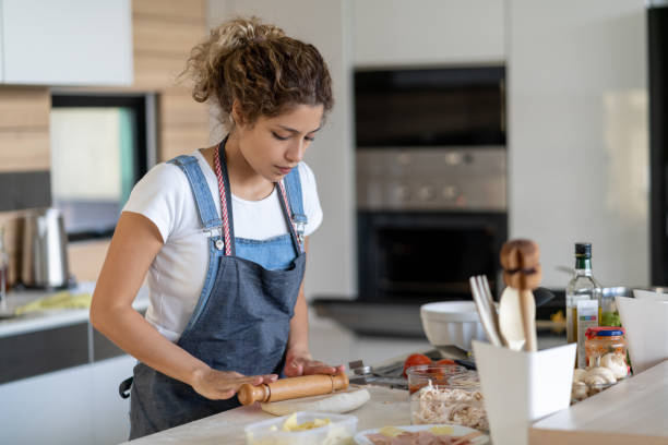 istock Woman kneading the dough while making homemade pizza 1248066393