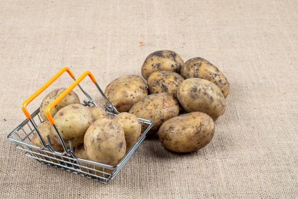 istock potatoes on a sackcloth covered table with a shopping basket 1248081676