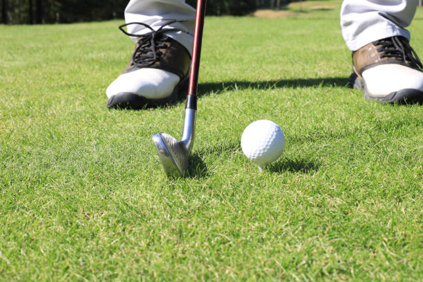 istock Golf player at the putting green hitting ball into a hole. 1248087964