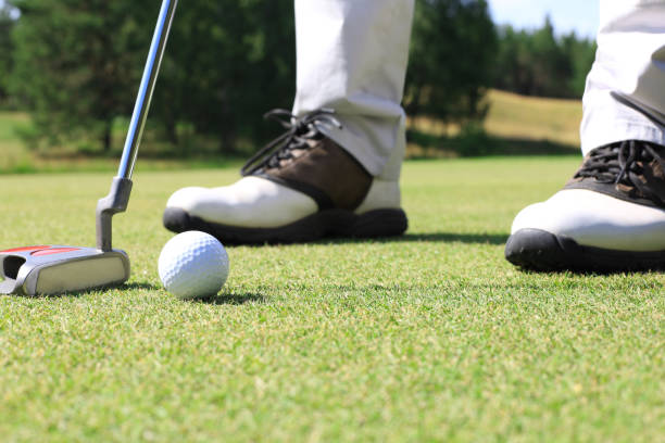 istock Golf player at the putting green hitting ball into a hole. 1248087972