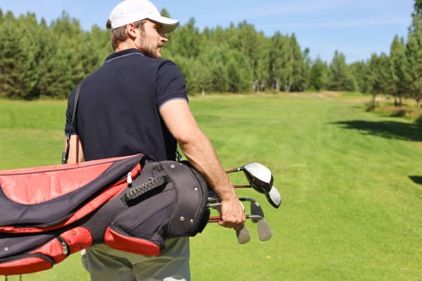 istock Golf player walking and carrying bag on course during summer game golfing. 1248088073