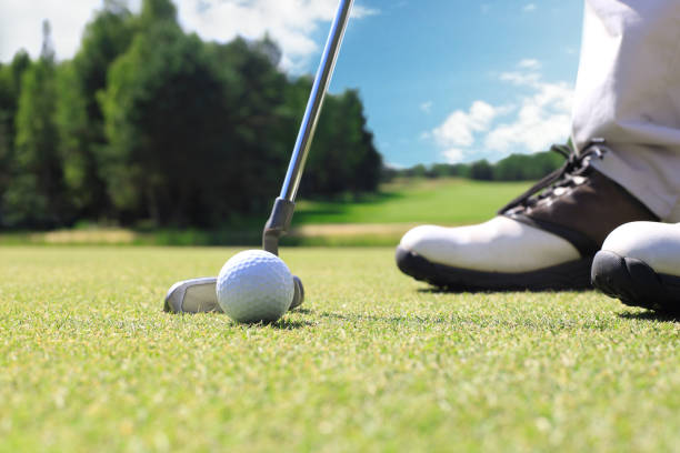 istock Golf player at the putting green hitting ball into a hole. 1248088086