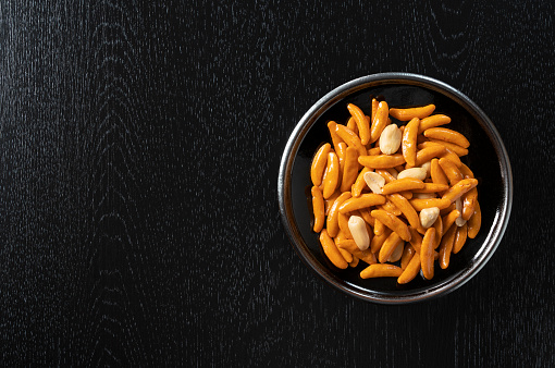 crispy rice crackers with roasted peanuts placed on a black background