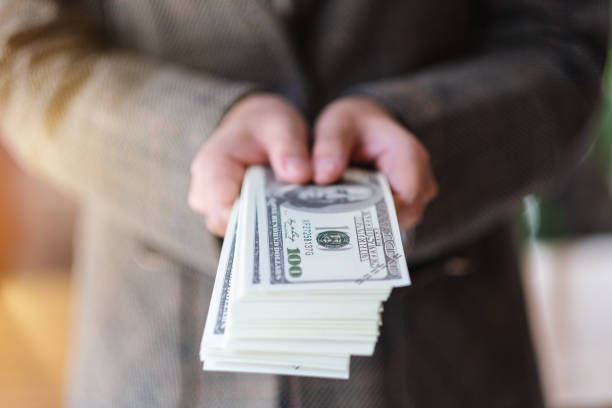 una donna in possesso e mostrando banconote in dollari americani per il denaro e il concetto finanziario - number 100 bill currency usa foto e immagini stock