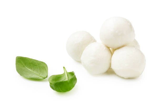 istock Mini Mozaarella cheese balls with fresh basil leaves isolated on white background. Heap of Mozzarella cheese. 1248117784