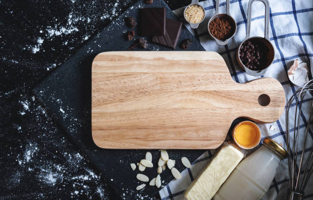 istock Top view, preparation for making homemade bakery. Empty wooden tray with chocolate, cocoa, egg, butter, egg, flour, almond,milk and raisin 1248124039
