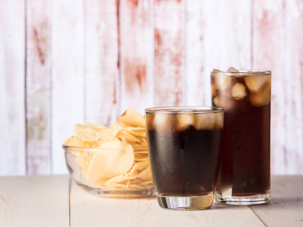 istock Cola glass with potato chips on a wood 1248124411