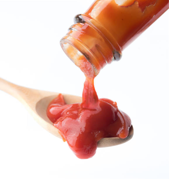 istock Tomato ketchup falling from bottle into spoon on white background 1248124555
