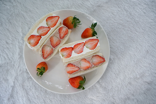 A white bread with fresh whipping cream and chocolate cream, topped with fresh strawberry.