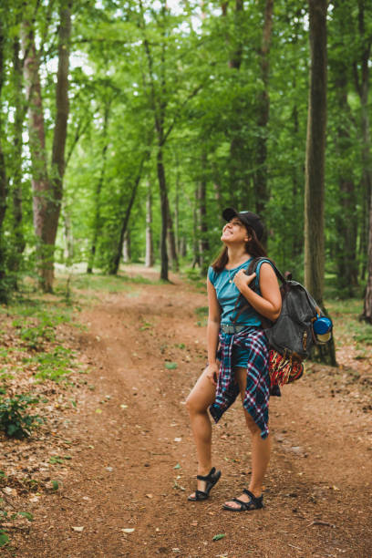 istock young adult woman walking with backpack by forest trail 1248125713