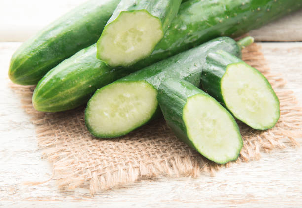 istock Cucumber and slices on wood background. 1248125922