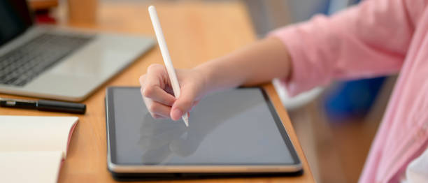 istock Female college student doing her assignment with mock-up tablet, laptop and stationery 1248128984