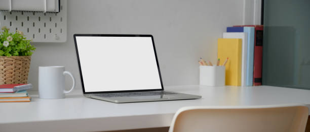 istock Modern worktable with mock-up laptop, cup, stationery, books and decorations on white desk 1248129023