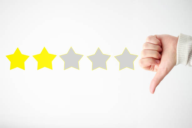 istock Woman's hand holds thumb down and stars, a concept low ranking 1248131134