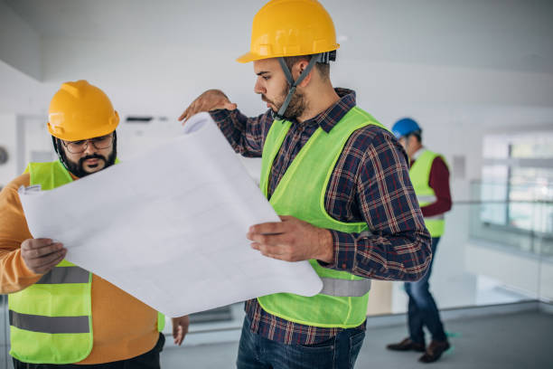istock Two male architects discussing building plans at construction site 1248134429