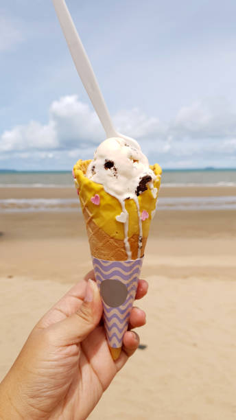 istock Melting ice cream on fancy cone with pastel paper wrap on human hand 1248136896
