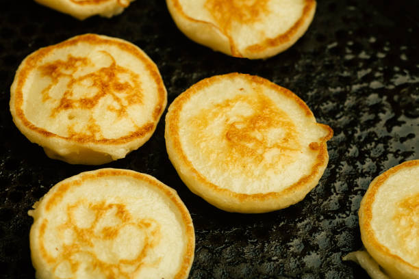 istock Tiny pancakes for breakfast. Tiny pancakes cooked in a pan in the kitchen. 1248138233