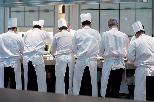 Group of chefs in white uniform busy to preparing food for they client