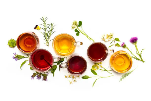 Various colorful herbal tea collection in glass cups on white background isolated