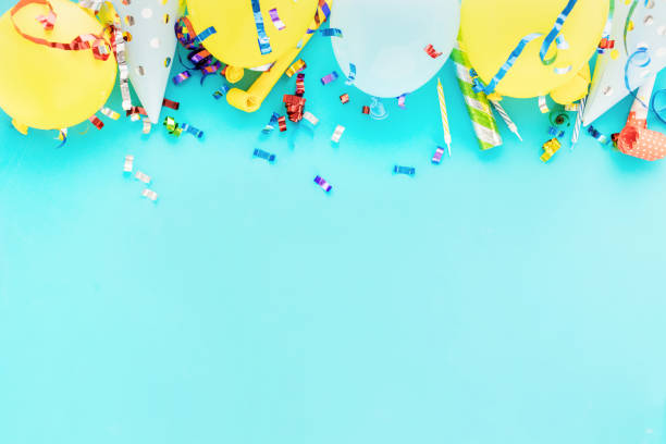 fond de ballon d’anniversaire avec des streamers colorés de partie, des confettis et des chapeaux de partie d’anniversaire sur la vue supérieure bleue de bacground - bacground photos et images de collection