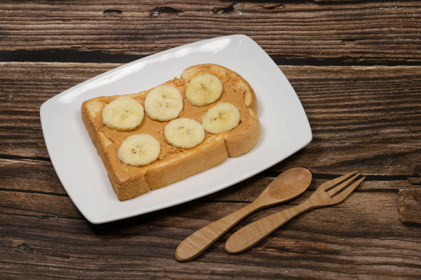 istock Sliced bread with peanut butter and banana top view 1248144687