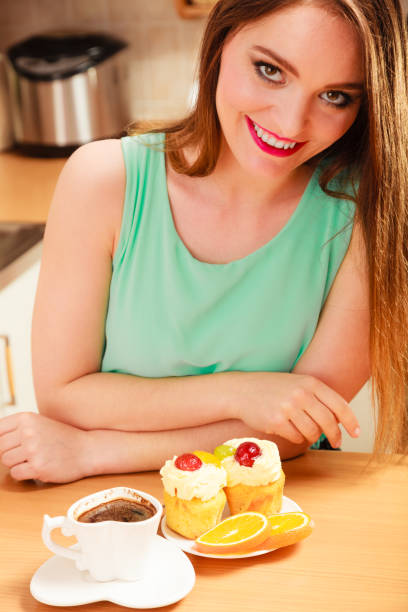 istock Woman with coffee and cake in kitchen. Gluttony. 1248152073