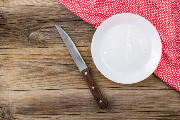 istock Table setting with red white napkin plate and knife on wooden table 1248154086