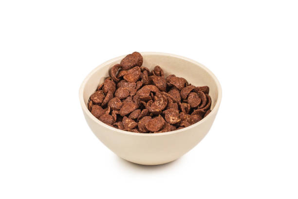 istock Chocolate corn flakes falling to the white bowl isolated on white. Motion. 1248157062