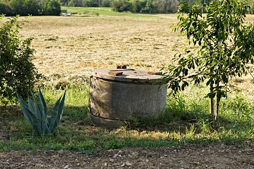 Concrete well closed with cover in the countryside (Pesaro, Italy, Europe)