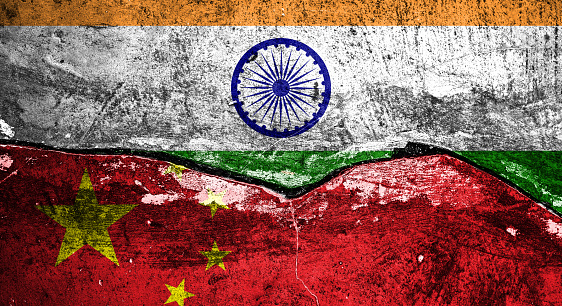 Image of Cracked brick wall painted with Indian flag on the top and a Chinese flag on the below - Trade War, Conflict Concept.