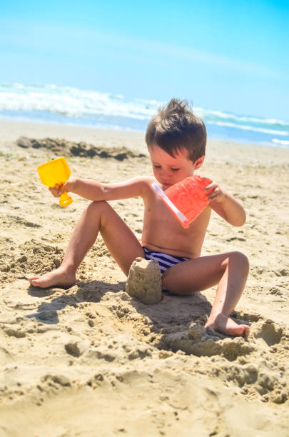 istock a boy plays with sand and builds sand castles on the seashore. summer mood 1248161027