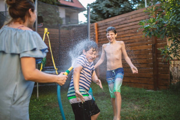istock Mother splashing laughing kids in back yard 1248161325