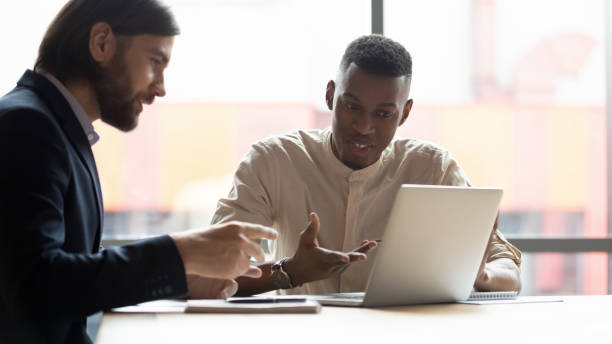 istock Multi-ethnic businessmen looking at laptop screen discussing new application 1248161402