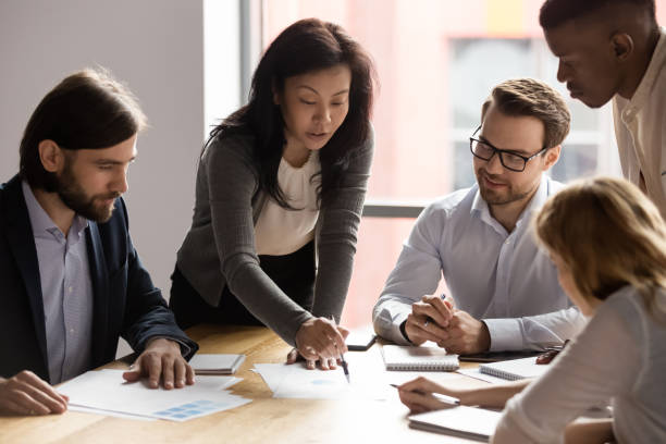 istock Five diverse business workgroup with asian woman leader discuss report 1248161445