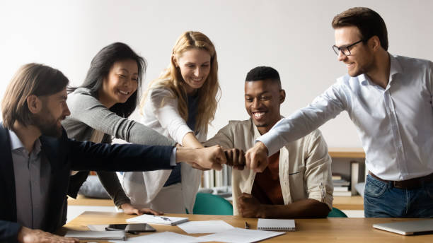 istock Five multiracial staff members show unity stacked hands in circle 1248161447
