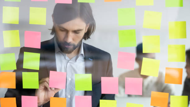 istock Businessman writing on attached multicolored sticky notes new ideas 1248161458