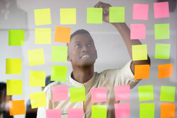 African worker writing on colorful sticky notes produces fresh ideas