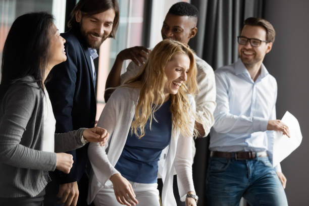 Five diverse colleagues enjoy common success celebrating successful deal closing