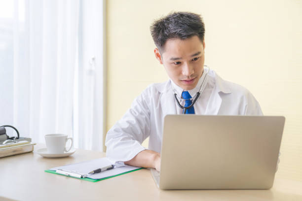 istock Young asian Doctor consulting using digital tablet working on diagnostic examination on men's health disease or mental illness, and writing on prescription record information document in clinic or hospital office medical concept 1248163836